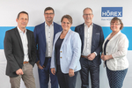 Der Aufsichtsrat der HÖREX: zwei Frauen, drei Männer vor einer Wand mit HÖREX Logo